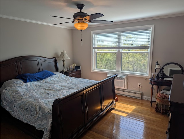 bedroom featuring crown molding, light wood-style floors, a ceiling fan, baseboards, and a baseboard heating unit