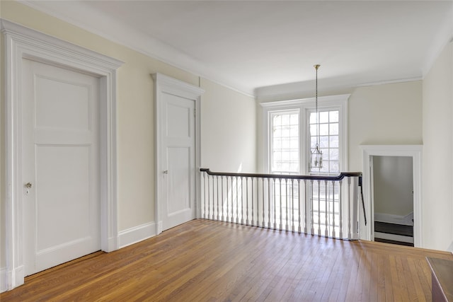 unfurnished room featuring baseboards, ornamental molding, and hardwood / wood-style floors