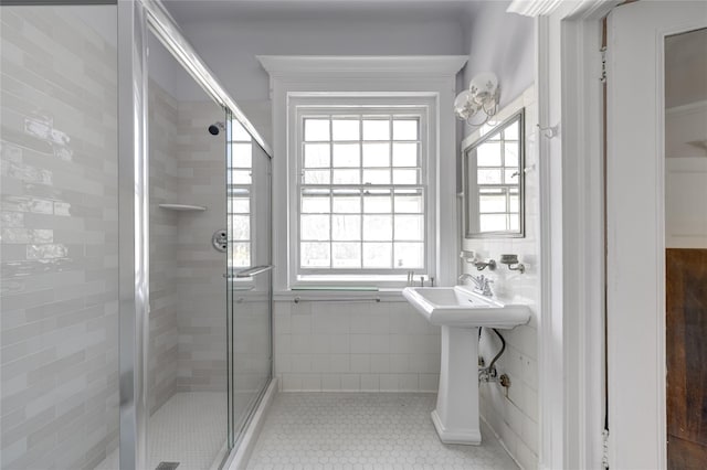 bathroom featuring a healthy amount of sunlight, tile patterned flooring, and a stall shower