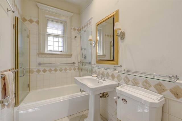 full bathroom featuring wainscoting, toilet, tile patterned floors, shower / washtub combination, and tile walls