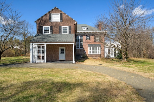 view of front of property featuring brick siding and a front lawn