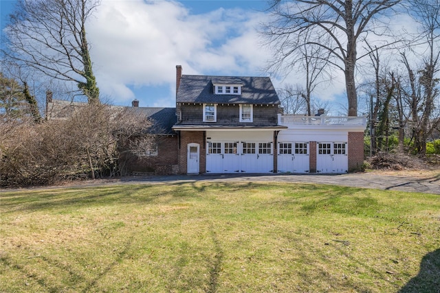 traditional-style home with brick siding, a front lawn, and a chimney