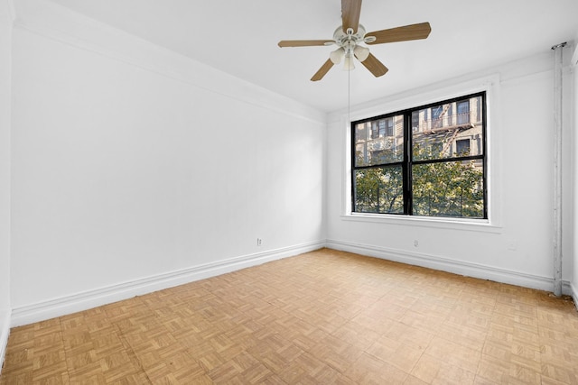unfurnished room with baseboards and a ceiling fan