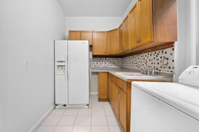 laundry room featuring washer / dryer, cabinet space, light tile patterned flooring, and baseboards