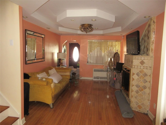 3922 Ely Ave, Bronx, NY 10466 - living room featuring a raised ceiling, a tile fireplace, radiator, and hardwood / wood-style floors