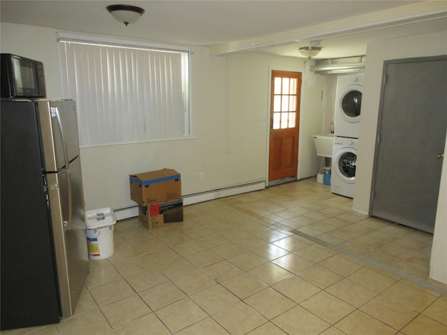 3922 Ely Ave, Bronx, NY 10466 - laundry room featuring laundry area, a baseboard heating unit, light tile patterned floors, and stacked washer and clothes dryer
