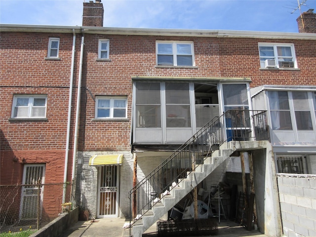 3922 Ely Ave, Bronx, NY 10466 - rear view of property with brick siding, a chimney, stairs, and a sunroom