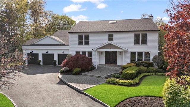 17 The Drawbridge, Woodbury, NY 11797 - colonial house with a shingled roof, an attached garage, aphalt driveway, a front yard, and a chimney