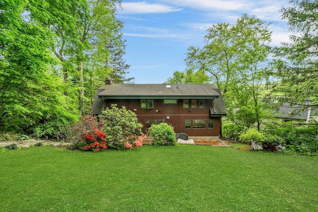 38A Claremont Rd, Scarsdale, NY 10583 - rear view of house featuring a chimney, a yard, and roof with shingles