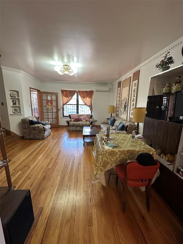 living room featuring crown molding, an AC wall unit, and wood finished floors