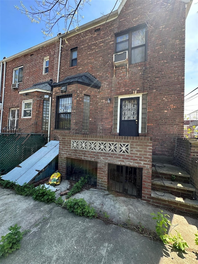 rear view of house with brick siding and fence