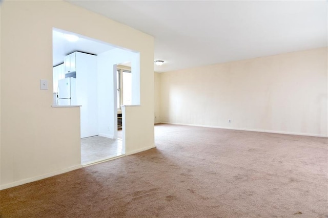 carpeted empty room with baseboards
