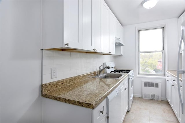 kitchen with under cabinet range hood, radiator, white appliances, white cabinets, and tasteful backsplash