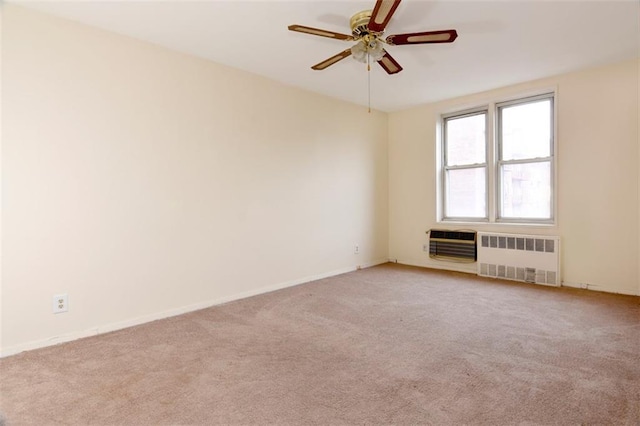 unfurnished room with radiator, baseboards, ceiling fan, and light colored carpet