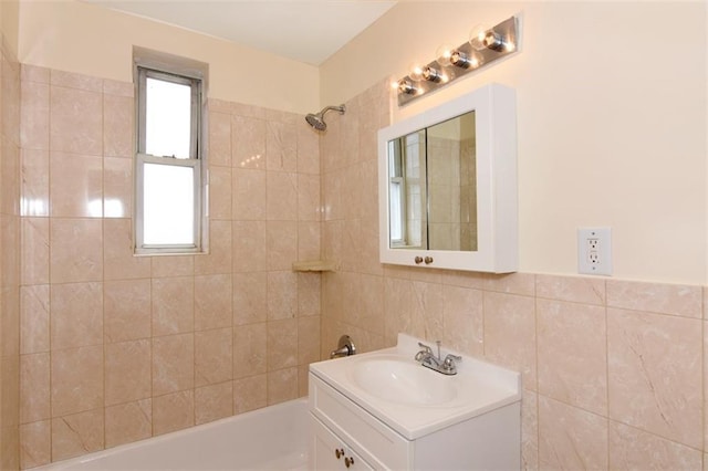 bathroom featuring tile walls, vanity, and bathtub / shower combination