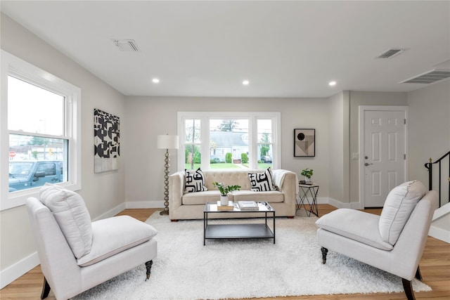 living room featuring baseboards, light wood-style flooring, and visible vents