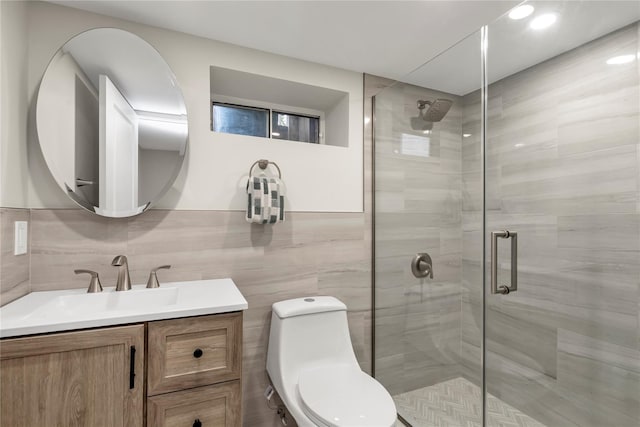 full bathroom with tile walls, vanity, and a shower stall