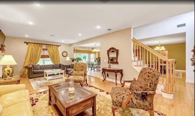 living area featuring visible vents, recessed lighting, wood finished floors, and a notable chandelier