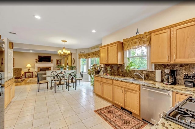 kitchen featuring light tile patterned floors, tasteful backsplash, stainless steel dishwasher, and a wealth of natural light