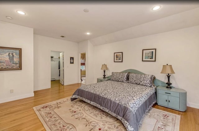 bedroom featuring baseboards, recessed lighting, light wood finished floors, and a baseboard radiator