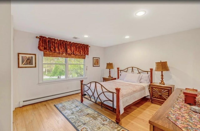 bedroom featuring light wood-style floors, recessed lighting, a baseboard heating unit, and visible vents
