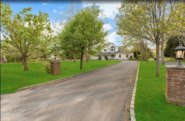 cape cod home featuring aphalt driveway and a front yard