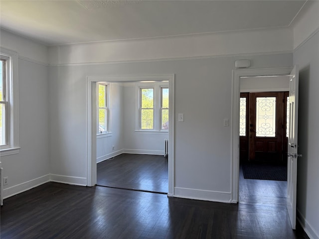foyer entrance with dark wood-type flooring and baseboards