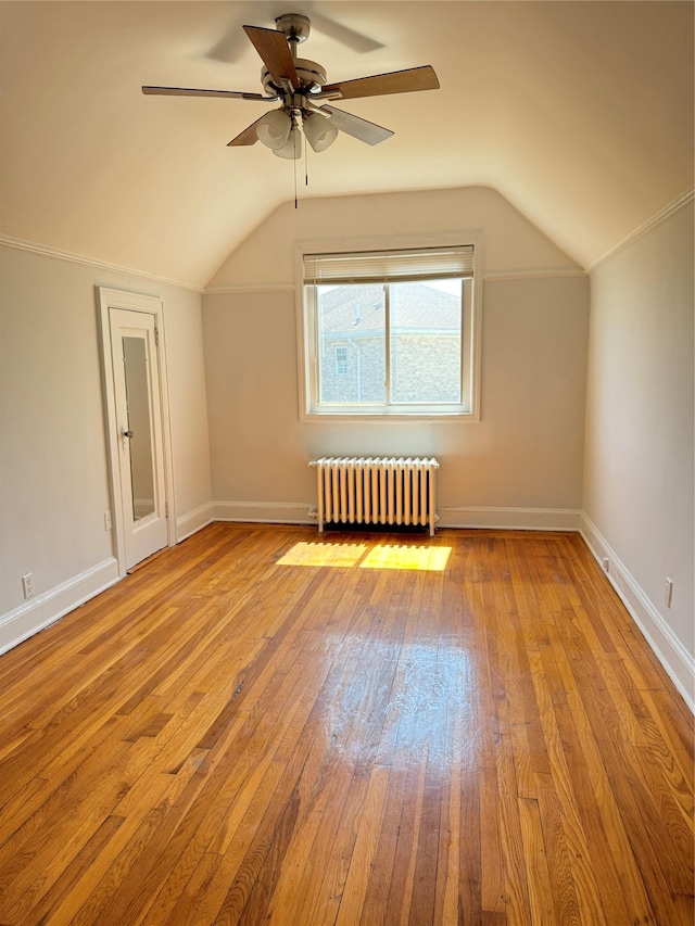 bonus room featuring ceiling fan, radiator, baseboards, lofted ceiling, and hardwood / wood-style flooring