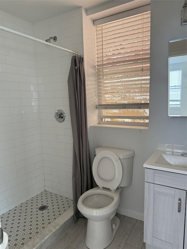 bathroom with vanity, baseboards, a stall shower, and toilet