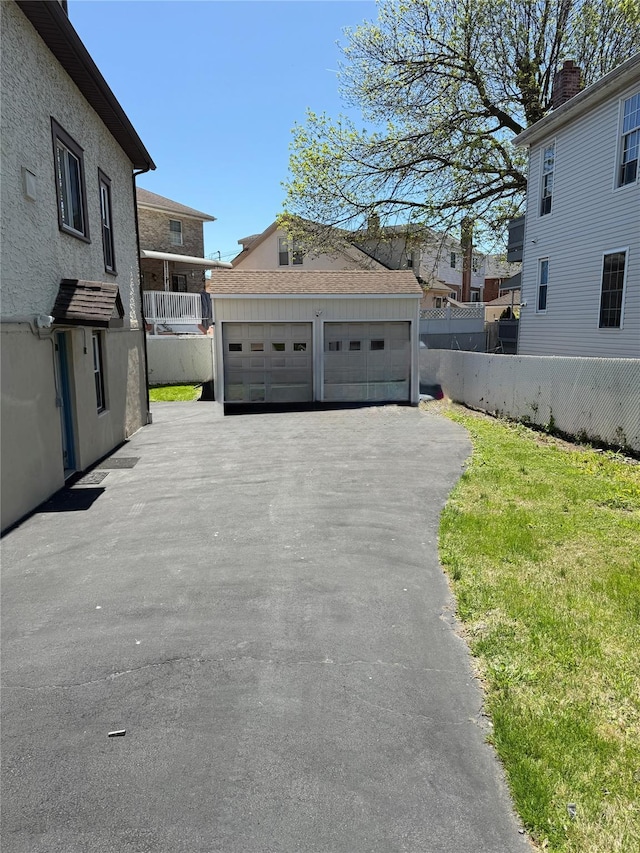 exterior space with an outdoor structure, fence, and a detached garage