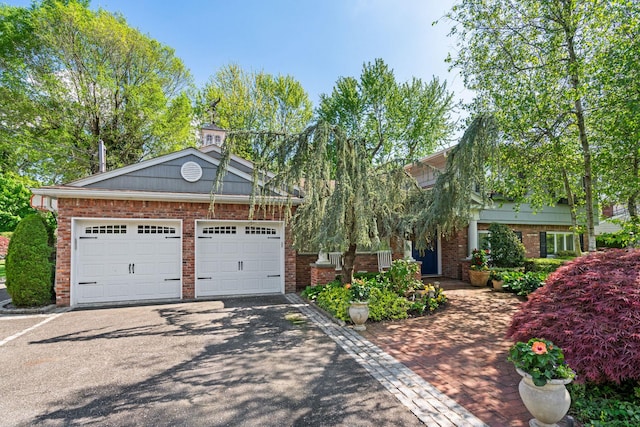 view of front of property with driveway, brick siding, and an attached garage