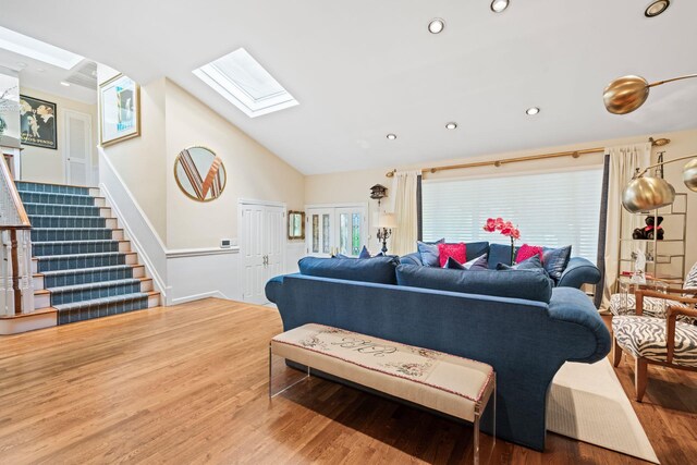 living area featuring a skylight, wood finished floors, stairway, lofted ceiling, and recessed lighting