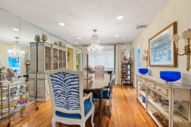 dining room with a chandelier, wood finished floors, and recessed lighting