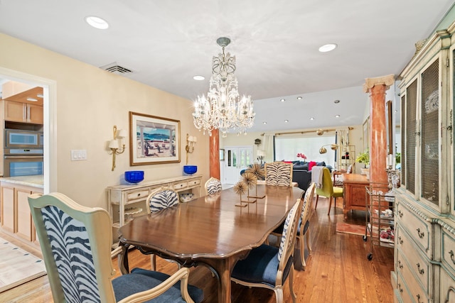 dining area featuring recessed lighting, light wood-style flooring, and a chandelier