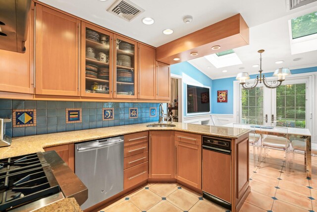 kitchen featuring a sink, dishwasher, a skylight, a peninsula, and a chandelier