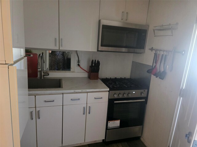 21 Krause St, Bay Shore, NY 11706 - kitchen with stainless steel appliances, a sink, light countertops, white cabinetry, and decorative backsplash