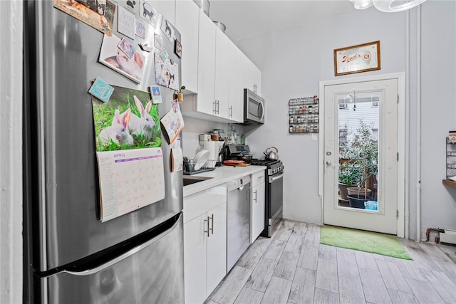 2504 21st St, Astoria, NY 11102 - kitchen with light countertops, light wood-style flooring, stainless steel appliances, and white cabinetry