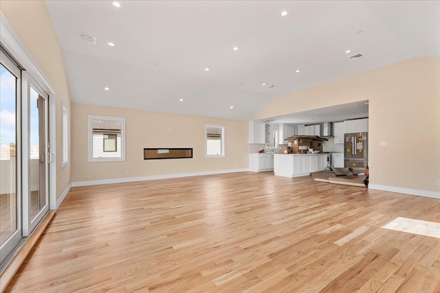 56 Oregon St, Long Beach, NY 11561 - unfurnished living room featuring visible vents, light wood-style flooring, baseboards, and vaulted ceiling