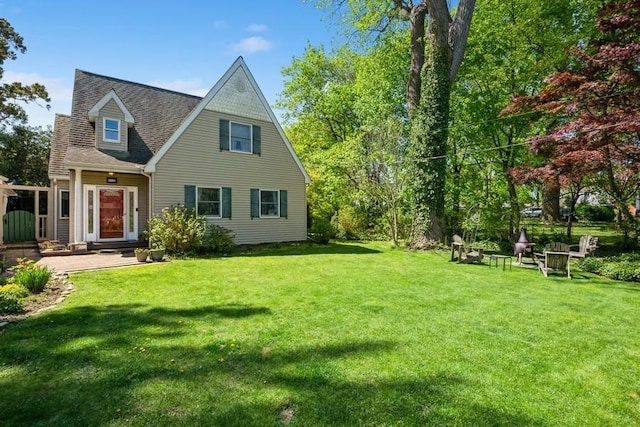 exterior space with a shingled roof and a yard