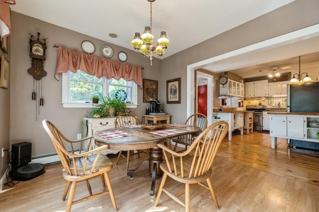 dining area with an inviting chandelier and light wood finished floors