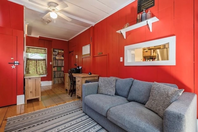 living area with crown molding, ceiling fan, and wood-type flooring