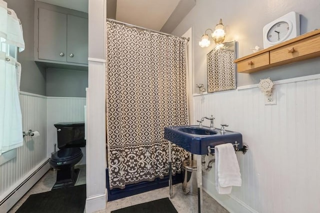 bathroom with a shower with shower curtain, toilet, a wainscoted wall, and a baseboard radiator