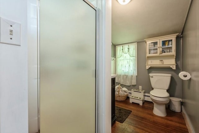 bathroom with a stall shower, toilet, and wood finished floors
