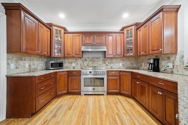30 Warwick Lake Pkwy, Warwick, NY 10990 - kitchen featuring stainless steel appliances, under cabinet range hood, light wood-type flooring, and glass insert cabinets
