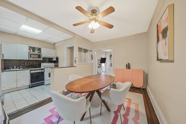 dining space with ceiling fan, baseboards, and light wood finished floors