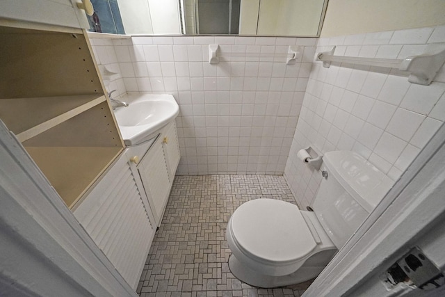 bathroom with tile walls, vanity, and toilet