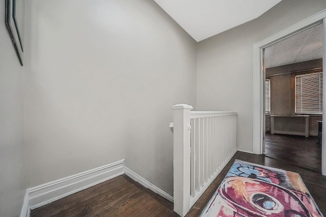 hallway featuring wood finished floors and an upstairs landing