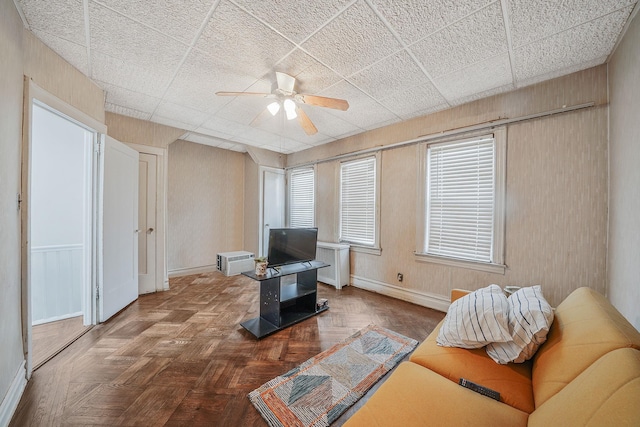 living room featuring ceiling fan, baseboards, and radiator