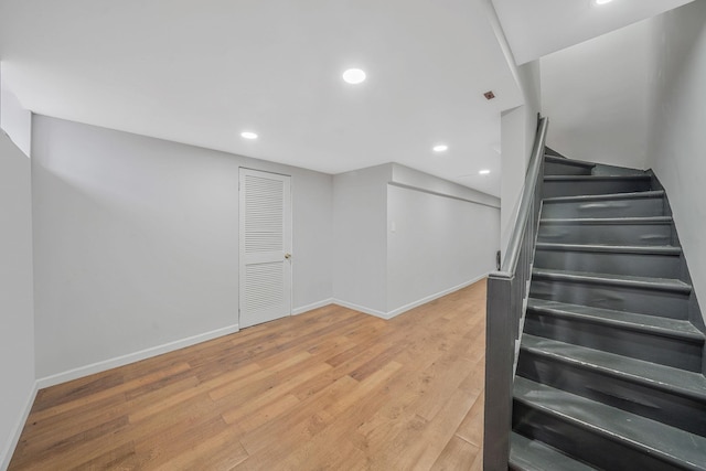 stairway featuring baseboards, recessed lighting, and wood finished floors