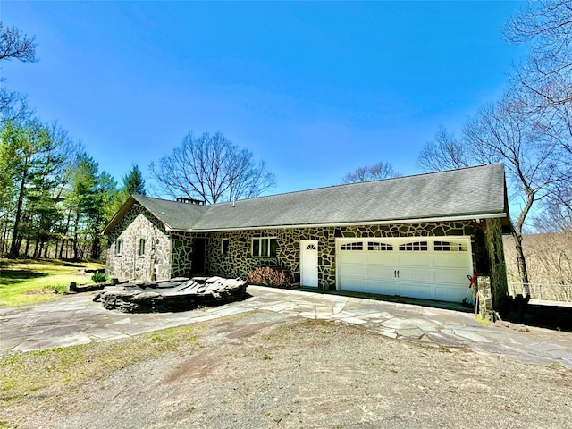 single story home with an attached garage, concrete driveway, and stone siding